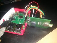 A Raspberry Pi in a red case, jumper-wired to a UWB board
